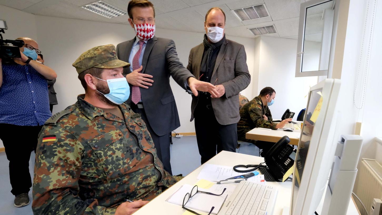 OB Marcus König und Bürgermeister Christian Vogel (rechts) schauen einem Soldaten über die Schulter, der Infizierte anruft und Kontaktpersonen in Quarantäne schickt. Noch bis mindestens Anfang Dezember sollen die Uniformierten im Gesundheitsamt mithelfen. 