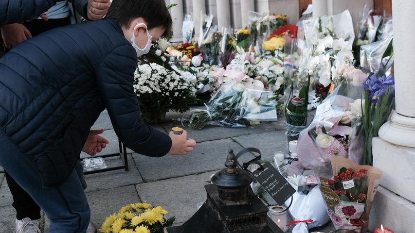 Ein Junge stellt ein Teelicht zwischen Blumen vor der Notre-Dame-Basilika ab: In der südfranzösischen Küstenstadt Nizza hat es einen tödlichen Messerangriff mit drei Toten und mehreren Verletzten gegeben. Der Täter hat vermutlich einen islamistisch-fundamentalistischen Hintergrund.