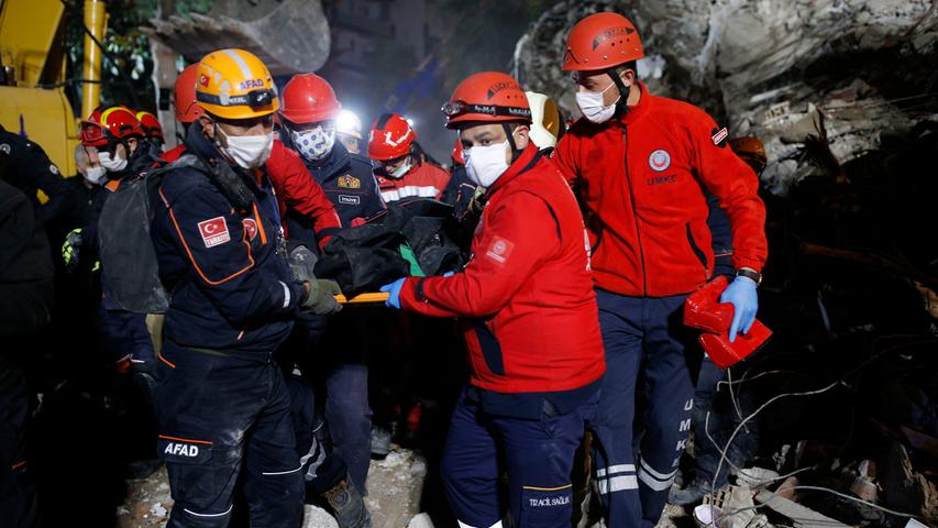 Rettungskräfte tragen ein Opfer aus den Trümmern eines eingestürzten Gebäudes in Izmir. Ein starkes Erdbeben in der Ägäis hat in der Westtürkei und auf den griechischen Inseln für große Zerstörung gesorgt.