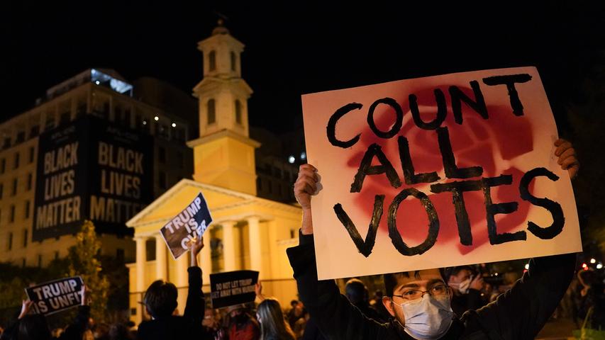 03.11.2020, USA, Washington: Ein Demonstrant hält am Tag der US-Präsidentschaftswahl ein Schild mit der Aufschrift "Count all votes" (zählt alle Stimmen) auf dem Black Lives Matter Plaza. Foto: John Minchillo/AP/dpa +++ dpa-Bildfunk +++