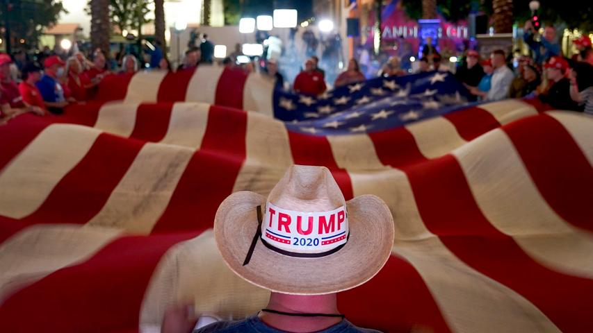 dpatopbilder - 04.11.2020, USA, Chandler: Anhänger von Präsident Donald Trump schwenken während einer Wahlparty eine Flagge (Recrop). Foto: Matt York/AP/dpa +++ dpa-Bildfunk +++