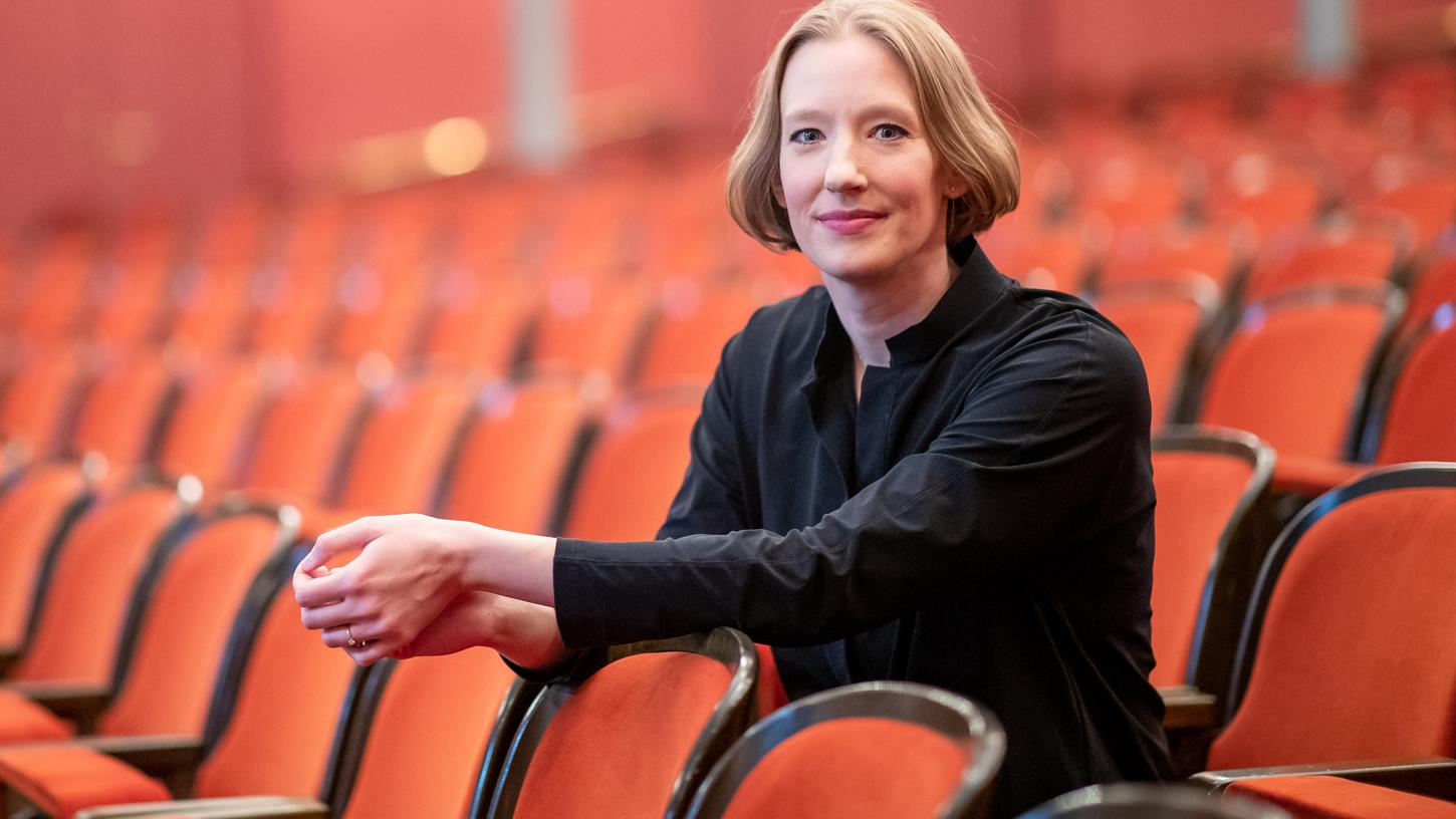 Joana Mallwitz, Dirigentin und  Generalmusikdirektorin am Staatstheater Nürnberg, sitzt im Opernhaus im Zuschauerbereich.