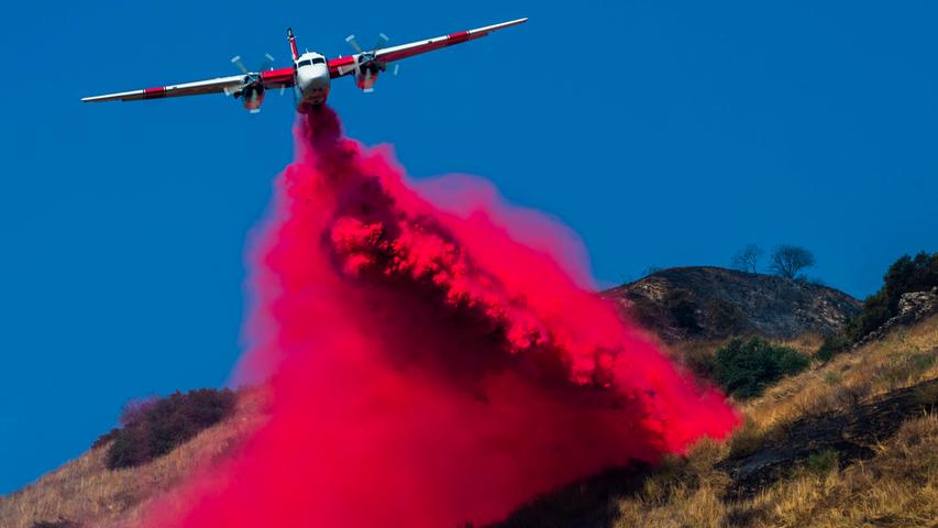 Seit Wochen wüten immer wieder gewaltige Waldbrände in Kalifornien. Hier verteilt ein Flugzeug Flammschutzmittel auf steiles Gelände beim San Dimas Canyon zwischen Los Angeles und San Bernardino.
