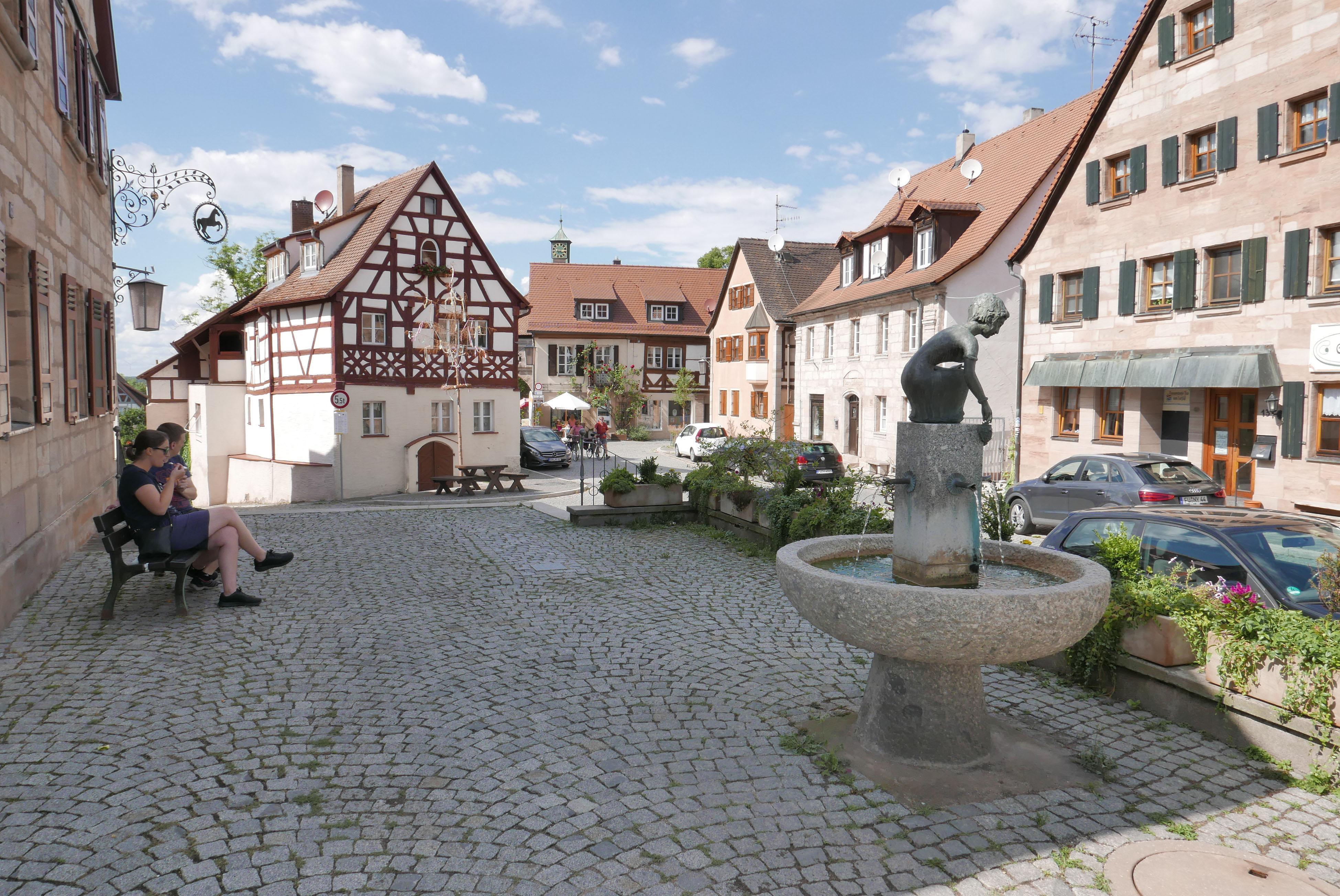 Der Cadolzburger Marktplatz mit Brunnen und dem Blick Richtung Burg.