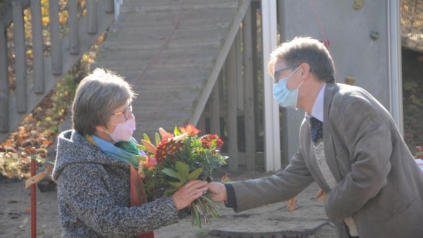 Pfarrer Wilfried Lechner-Schmidt überreicht einen Blumenstrauß.