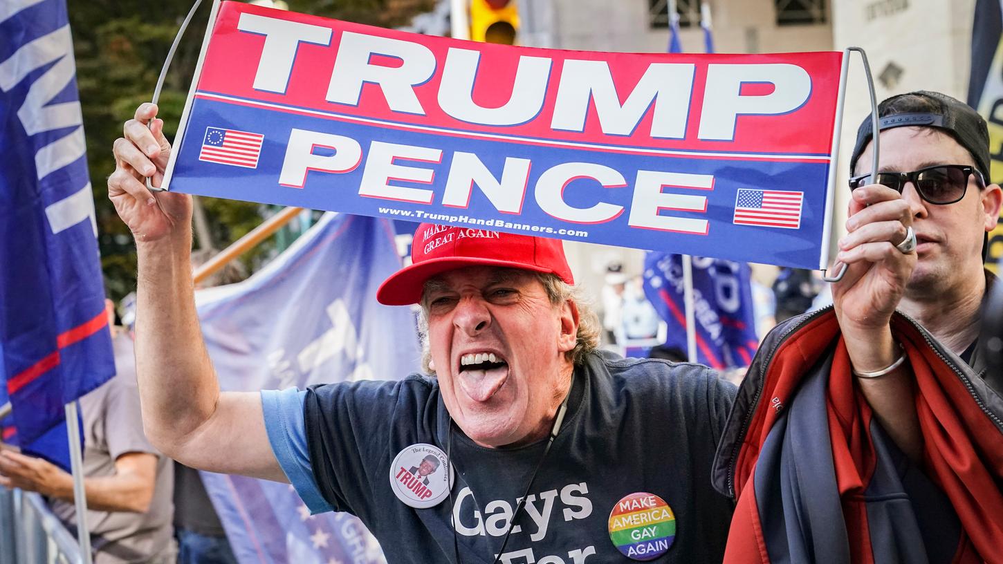 Ein verärgerter Anhänger von US-Präsident Trump gestikuliert in einer Menge feiernder Demonstranten nach den Präsidentschaftswahlen.