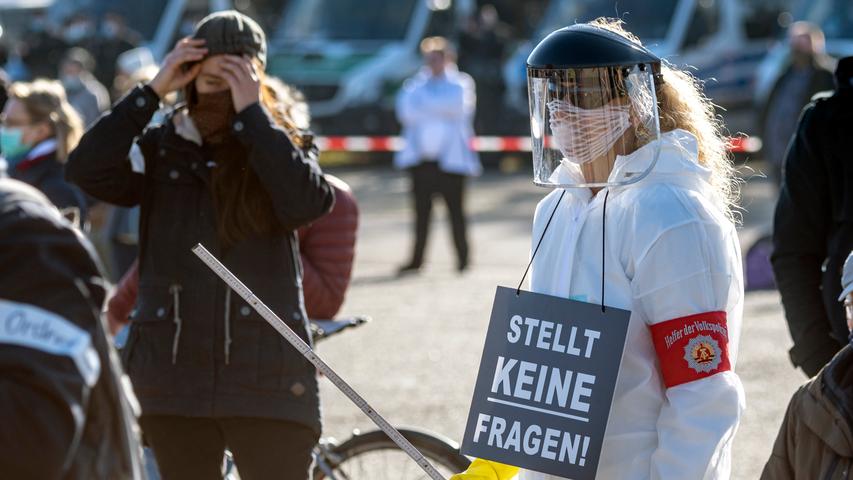 14.11.2020, Bayern, Regensburg: Eine Teilnehmerin einer Demonstration der «Querdenken»-Bewegung gegen die Anti-Corona-Maßnahmen hält bei einer Kundgebung auf dem Dultplatz ein Schild ·mit der Aufschrift "Stellt keine Fragen!"·. Foto: Armin Weigel/dpa +++ dpa-Bildfunk +++