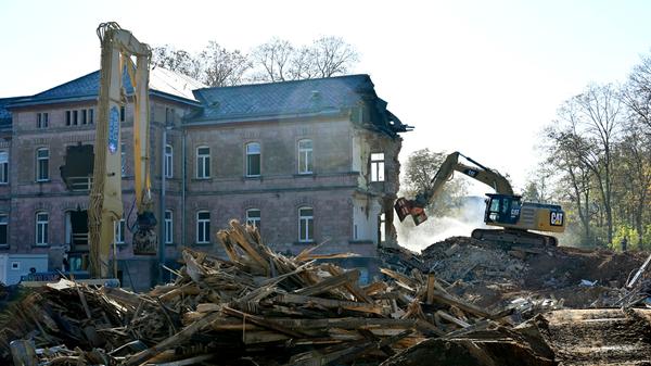 Der Abrisses großer Teile der Heil- und Pflegeanstalt (Hupfla) schreitet voran: Nicht der Zahn der Zeit und allgemeine Vergänglichkeit nagen derzeit an dem einzig verbliebenen Patientengebäude, sondern schlicht der Plan hier Institute und Forschungseinrichtugen neu zu bauen. Im Bild: Der Westflügel von Norden gesehen, wird zunehmend von Baggerzähnen zermalmt.