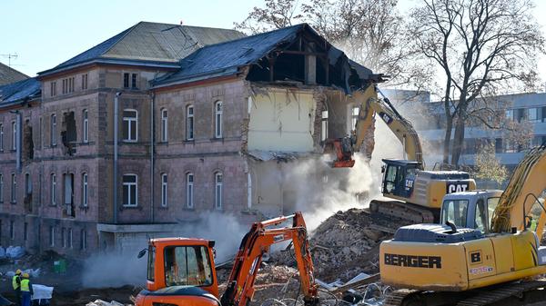 Der Abrisses großer Teile der Heil- und Pflegeanstalt (Hupfla) schreitet voran: Nicht der Zahn der Zeit und allgemeine Vergänglichkeit nagen derzeit an dem einzig verbliebenen Patientengebäude, sondern schlicht der Plan hier Institute und Forschungseinrichtugen neu zu bauen. Im Bild: Der Westflügel von Norden gesehen, wird zunehmend von Baggerzähnen zermalmt.