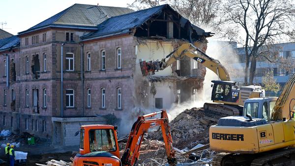 Der Abrisses großer Teile der Heil- und Pflegeanstalt (Hupfla) schreitet voran: Nicht der Zahn der Zeit und allgemeine Vergänglichkeit nagen derzeit an dem einzig verbliebenen Patientengebäude, sondern schlicht der Plan hier Institute und Forschungseinrichtugen neu zu bauen. Im Bild: Der Westflügel von Norden gesehen, wird zunehmend von Baggerzähnen zermalmt.