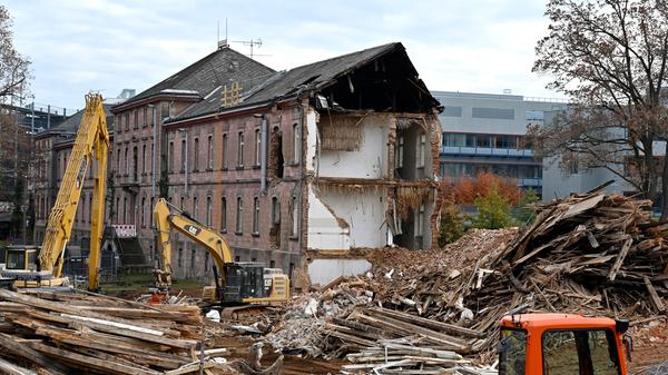 Der Abrisses großer Teile der Heil- und Pflegeanstalt (Hupfla) schreitet voran: Nicht der Zahn der Zeit und allgemeine Vergänglichkeit nagen derzeit an dem einzig verbliebenen Patientengebäude, sondern schlicht der Plan hier Institute und Forschungseinrichtugen neu zu bauen. Im Bild: Der Westflügel von Norden gesehen, wird zunehmend von Baggerzähnen zermalmt.