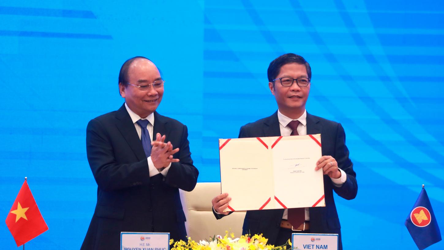 Premierminister von Vietnam, applaudiert als Tran Tuan Anh, Handelsminister von Vietnam, hält ein unterzeichnetes Dokument während eines Online-Gipfels der südostasiatischen Staatengemeinschaft Asean hoch.