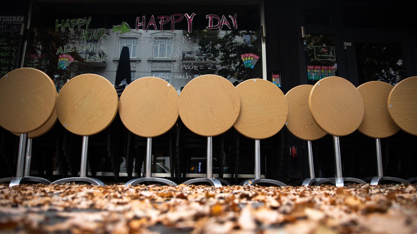 Leere Tische stehen vor einer geschlossenen Bar. (Symbolbild)