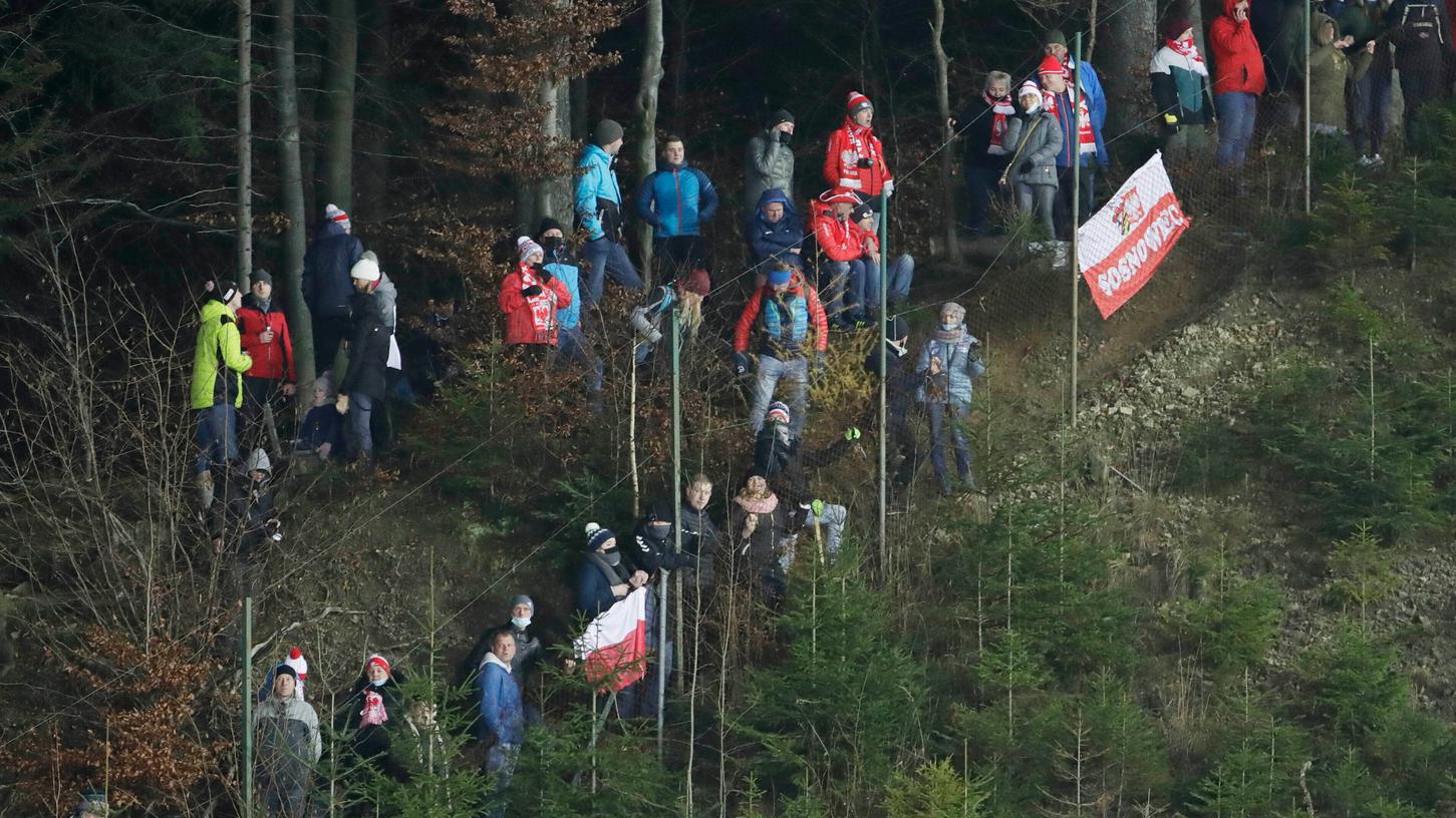 Polnische Skisprung-Fans beim Schanzen-Spektakel in Wisla vor dem Zaun.
