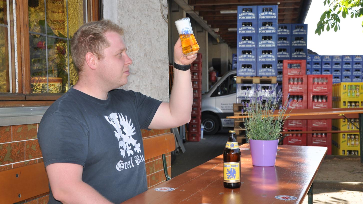Mit dem Blick des Fachmanns prüft Christian Schuster das von ihm gebraute, preisgekrönte Bier vor der heimischen Gaststätte.