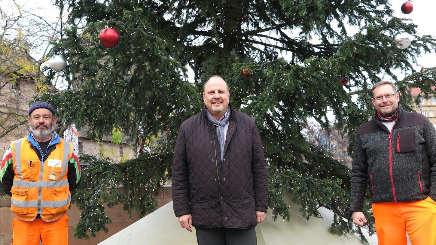 Bürgermeister Christian Vogel (Mitte) mit den  Sör-Mitarbeitern, die den Weihnachtsbaum am Bahnhofsplatz geschmückt haben. Foto: André Winkel/Stadt Nürnberg  