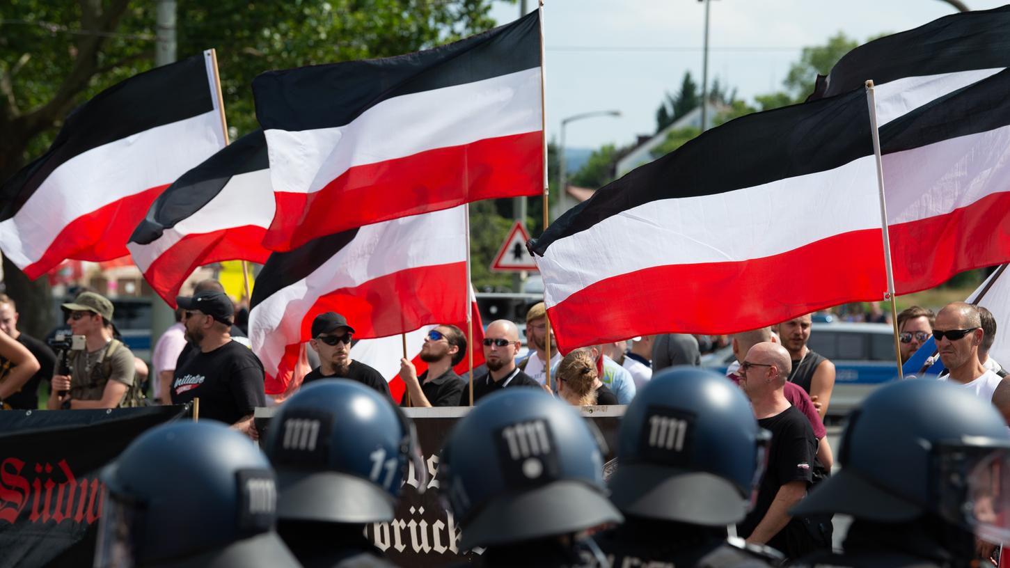 Anhänger der rechtsextremen Kleinstpartei "Die Rechte" lassen im Sommer bei einer Demonstration in Kassel ihre Fahnen wehen.