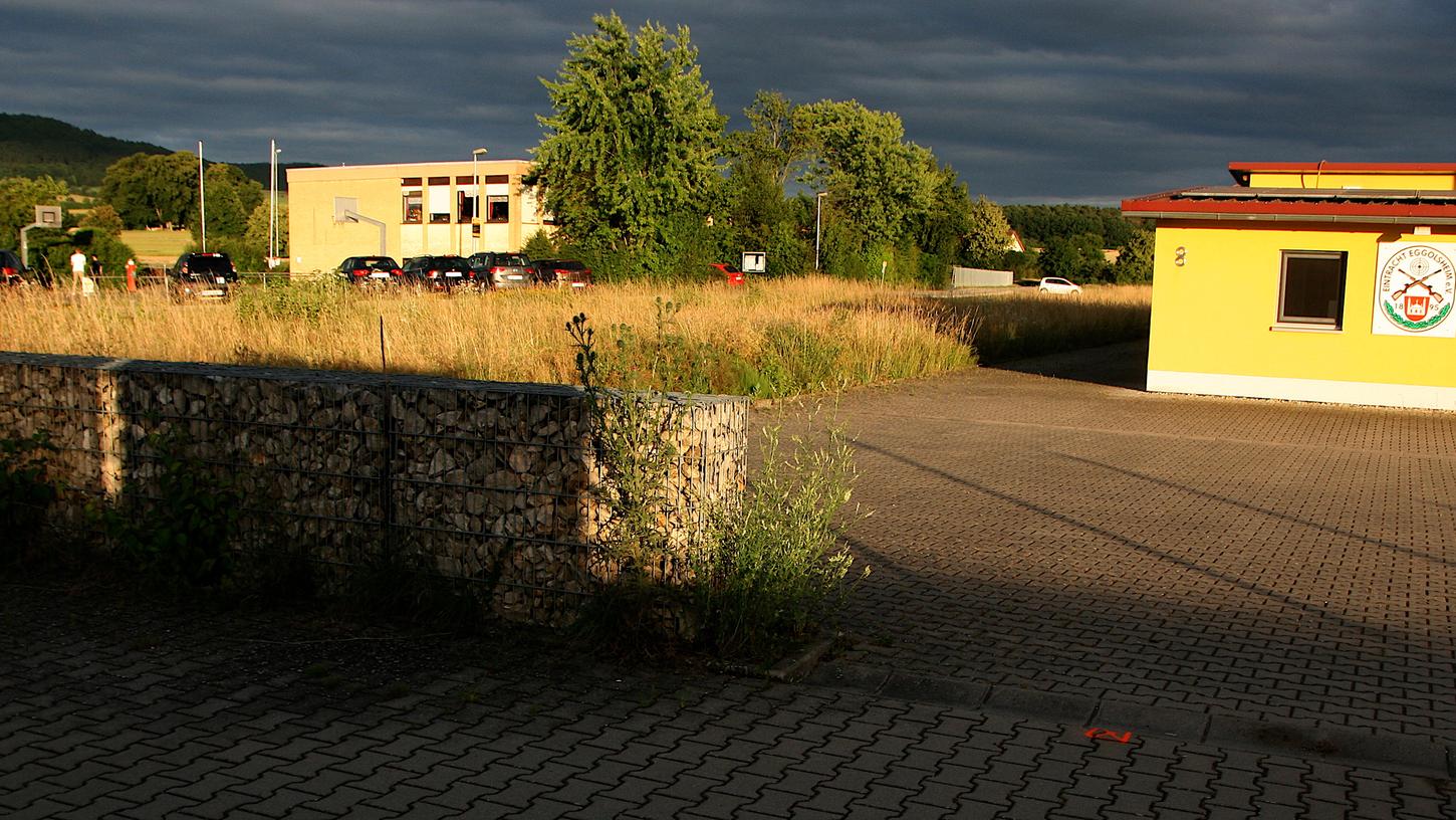 Die neue zentrale Kindertagesstätte soll in Eggolsheim zwischen Sport- und Schützenheim dort zu stehen kommen, wo auf dem Bild ein weißes Auto zu erkennen ist. Über diese Frage gab es im Gemeinderat Streit. 