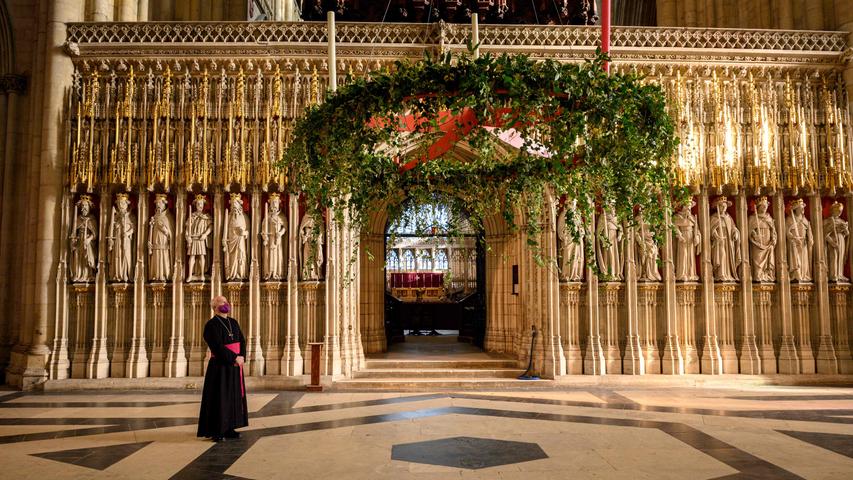 Stephen Cottrell, der Erzbischof von York, betrachtet einen riesigen Adventskranz, der im Inneren der Kathdrale der Stadt von oben auf seine endgültige Position herabgelassen wird. Es heißt, dieses Gebinde sei einer der größten Adventskränze in ganz England.