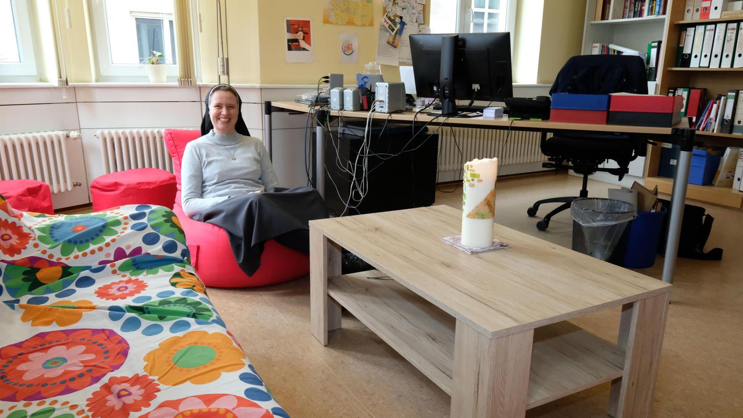 Mit Osterkerze und Sitzsäcken: Schwester Magdalena Winghofer in ihrem Erker-Büro im Haus der Katholischen Stadtkirche.   