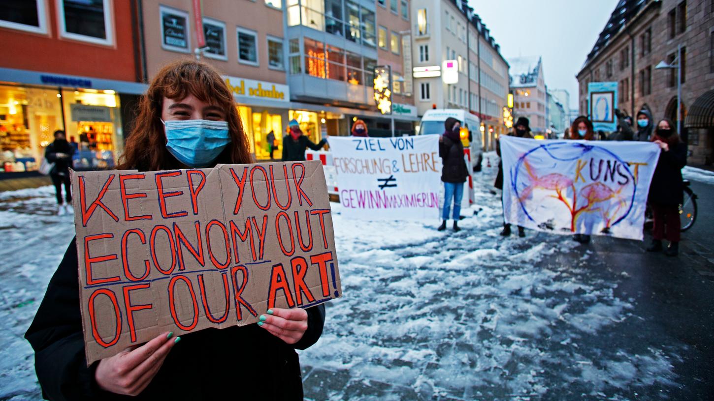 "Lasst die Wirtschaft bei unserer Kunst außen vor", fordert diese Studentin bei der Demonstration am Hallplatz.