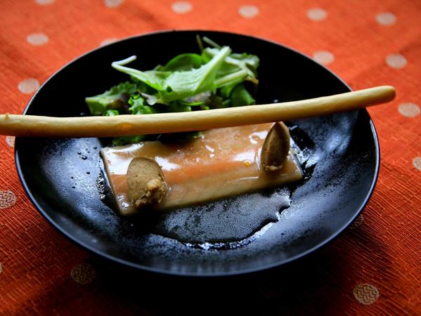 Ein leckeres Entrée: Ein zartes Saiblingsfilet mit einer fein-würzigen Marinade, dazu ein paar Brotkrüstchen und einen Hauch von grünem Salat, garniert mit einer Grissini-Stange.