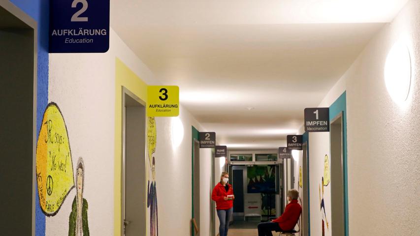 In einem der Räume im Erdgeschoss steht ein großer Flachbildschirm. Darauf ist ein Video zu sehen, das Fabian Hofmann, ASB-Azubi aus Oesdorf, mit seinem Smartphone gedreht hat. "Der offizielle Film liegt uns derzeit noch nicht vor", sagt Sebastian Beetz. Bis alle sechs Test-Patienten beisammen sind, bleibt Zeit für einen kleinen Plausch. Von Günther Mück aus Forchheim erfährt der Berichterstatter , dass wir uns in den ehemaligen Büros des Schülerwohnheims befinden. Die kennt Mück noch aus seiner Lehrzeit, als auch ein gewisser Lothar Matthäus hier den Beruf des Raumaustatters erlernte. Insgesamt stehen vier solcher Zimmer zur Verfügung. Im Aufklärungsgespräch dreht sich alles um die Chancen und Risiken der Impfung. Wer hinterher immer noch Fragen dazu hat, kann einen der Ärzte persönlich und vertraulich sprechen.
In einem der Räume im Erdgeschoss steht ein großer Flachbildschirm. Darauf ist ein Video zu sehen, das Fabian Hofmann, ASB-Azubi aus Oesdorf, mit seinem Smartphone gedreht hat. "Der offizielle Film liegt uns derzeit noch nicht vor", sagt Sebastian Beetz. Bis alle sechs Test-Patienten beisammen sind, bleibt Zeit für einen kleinen Plausch. Von Günther Mück aus Forchheim erfährt der Berichterstatter , dass wir uns in den ehemaligen Büros des Schülerwohnheims befinden. Die kennt Mück noch aus seiner Lehrzeit, als auch ein gewisser Lothar Matthäus hier den Beruf des Raumaustatters erlernte. Insgesamt stehen vier solcher Zimmer zur Verfügung. Im Aufklärungsgespräch dreht sich alles um die Chancen und Risiken der Impfung. Wer hinterher immer noch Fragen dazu hat, kann einen der Ärzte persönlich und vertraulich sprechen.