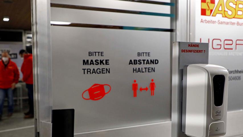 Auch mit dem Rollstuhl oder dem Rollator kommt man über eine Rampe stufenlos ins Innere des Gebäudees. Natürlich erst nach einer Händedesinfektion. Beim Betreten des Vorraums fällt der Blick auf drei Schalter. Hinter einer der Glasscheiben sitzt Sebastian Beetz. Zu ihm kamen am Mittwoch die Test-Patienten. Sie haben einen Aufklärungsbogen und einen Laufzettel mitgebracht, die sie von ihrem Hausarzt bekommen haben und zu Hause in Ruhe durchlesen konnten. Vom ASB-Geschäftsführer gibt es einen farbigen Punkt auf das Blatt. Fortan brauchen die Impfwilligen dann nur noch den gleichfarbigen Punkten auf dem Boden zu folgen, um an die nächste Station zu gelangen.
Auch mit dem Rollstuhl oder dem Rollator kommt man über eine Rampe stufenlos ins Innere des Gebäudees. Natürlich erst nach einer Händedesinfektion. Beim Betreten des Vorraums fällt der Blick auf drei Schalter. Hinter einer der Glasscheiben sitzt Sebastian Beetz. Zu ihm kamen am Mittwoch die Test-Patienten. Sie haben einen Aufklärungsbogen und einen Laufzettel mitgebracht, die sie von ihrem Hausarzt bekommen haben und zu Hause in Ruhe durchlesen konnten. Vom ASB-Geschäftsführer gibt es einen farbigen Punkt auf das Blatt. Fortan brauchen die Impfwilligen dann nur noch den gleichfarbigen Punkten auf dem Boden zu folgen, um an die nächste Station zu gelangen.