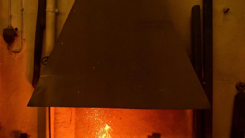 Albert Lechner schürt zunächst ein Feuer in der Esse, das eine Temperatur von fast 1000 Grad erreicht. Nur so wird das Eisenrohr ausreichend heiß und weich.