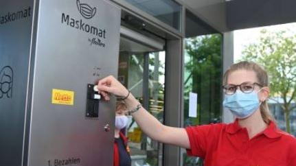 Automat (vor einem Geschäft), an dem ein einzeln verpackter Mund-Nasen-Schutz käuflich erworben werden kann
