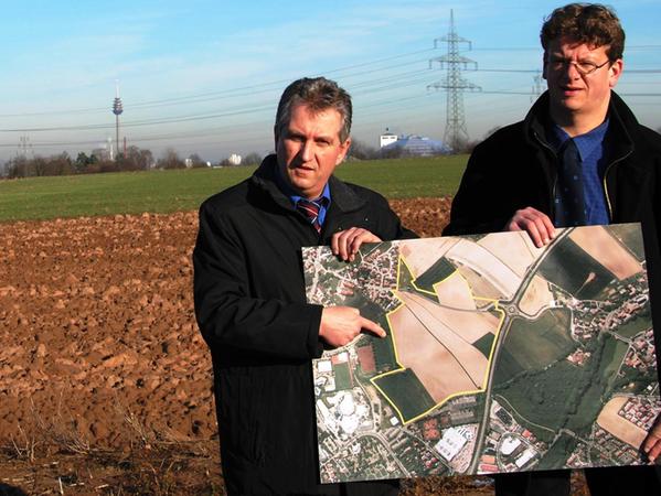 Anno 2012: Bürgermeister Kurt Krömer präsentiert mit Wolfgang Schaffrien vom Bauamt auf dem Weihersberg ein Luftbild. Das betreffende Areal ist gelb umrandet.