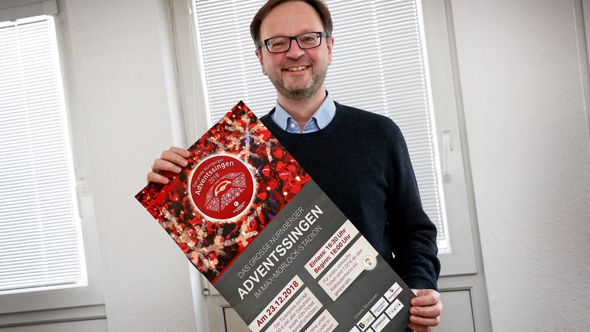 Herzogenaurachs evangelischer Kantor Gerald Fink - hier mit einem Werbeplakat für das 2020 ausgefallene Adventssingen - mag die fränkische Weise "Was soll das bedeuten: es taget ja schon" sehr gern.