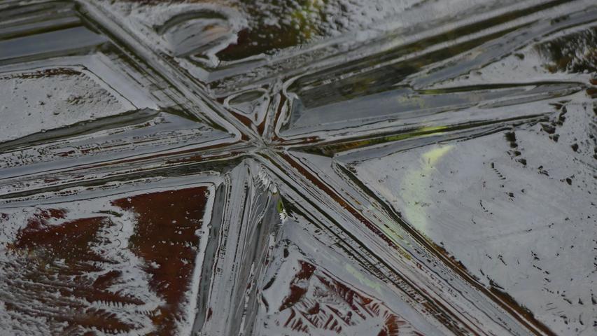 Ein tiefer Blick in gefrorenes Wasser offenbart Eiskristalle in Sternform.