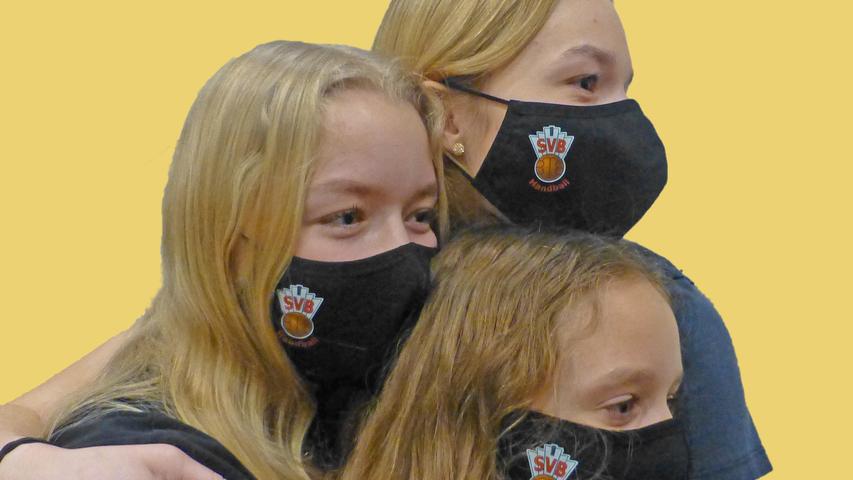 Gesichter des Jahres 2020: Die Schwestern Anna, Luisa und Sofia mit den Vereins-Masken der Handballer des SV Buckenhofen.