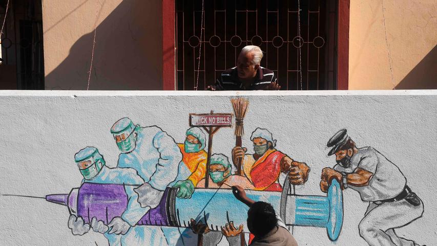 Die letzten Tage des Jahres 2020 standen ohnehin ganz im Zeichen des neuen Impfschutzes gegen das Coronavirus. Künstler gaben dem in Kalkutta Ausdruck und malten eine Spritze mit Impfstoff, getragen von Arbeitern. 