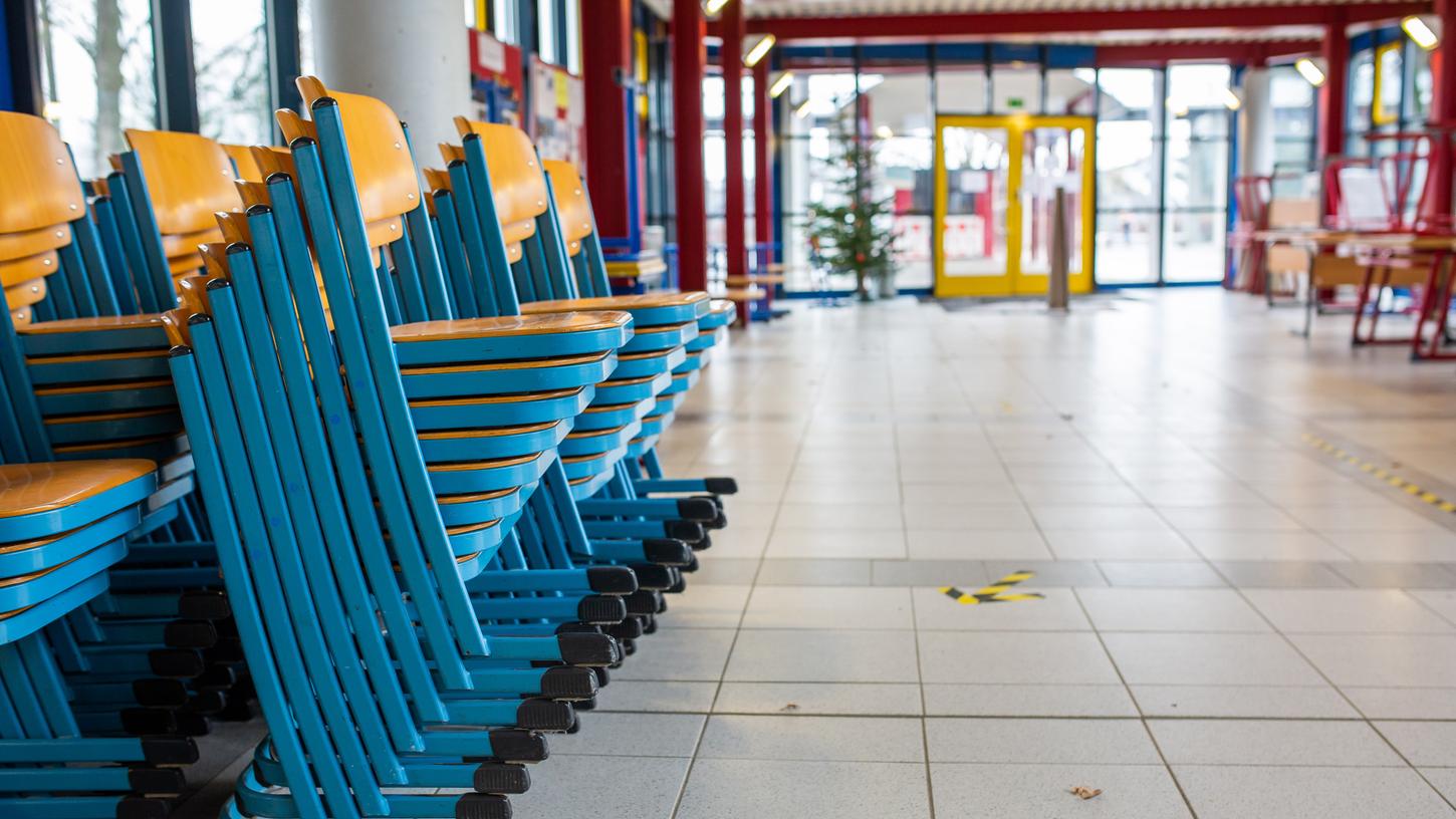 Gestapelte Stühle stehen im Eingangsbereich einer Realschule. Die Schulen setzten am 16.12.2020 den Präsenzunterricht aus.