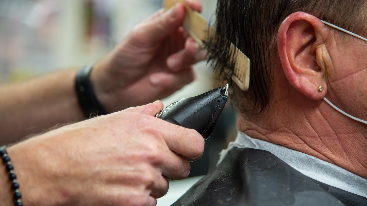 Ein Friseur schneidet einem Kunden die Haare. Der andauernde Lockdown macht den Friseurbetrieben zu schaffen.