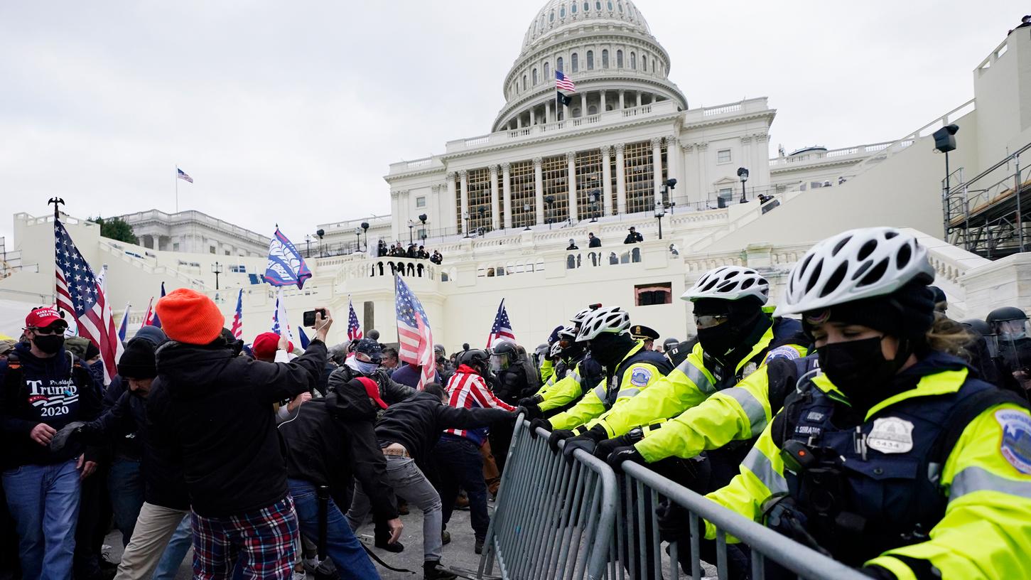 Unterstützer des US-Präsidenten Trump versuchen eine Absperrung vor dem Kapitol zu durchbrechen. 