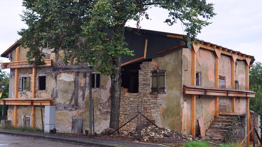 Von der Dorfstraße aus erkennt man gut das einstige Gasthaus (links) und das im 19. Jahrhundert angebaute, inzwischen stark verfallene Korbhaus (rechts).