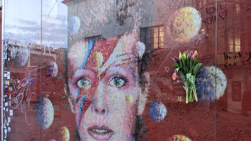 Kurz vor dem 5. Todestag sind Blumen und Botschaften am David-Bowie-Denkmal des australischen Künstlers James Cochran (Jimmy C) im Stadtteil Brixton, direkt gegenüber der U-Bahn-Station am Tunstall Place, zu sehen.