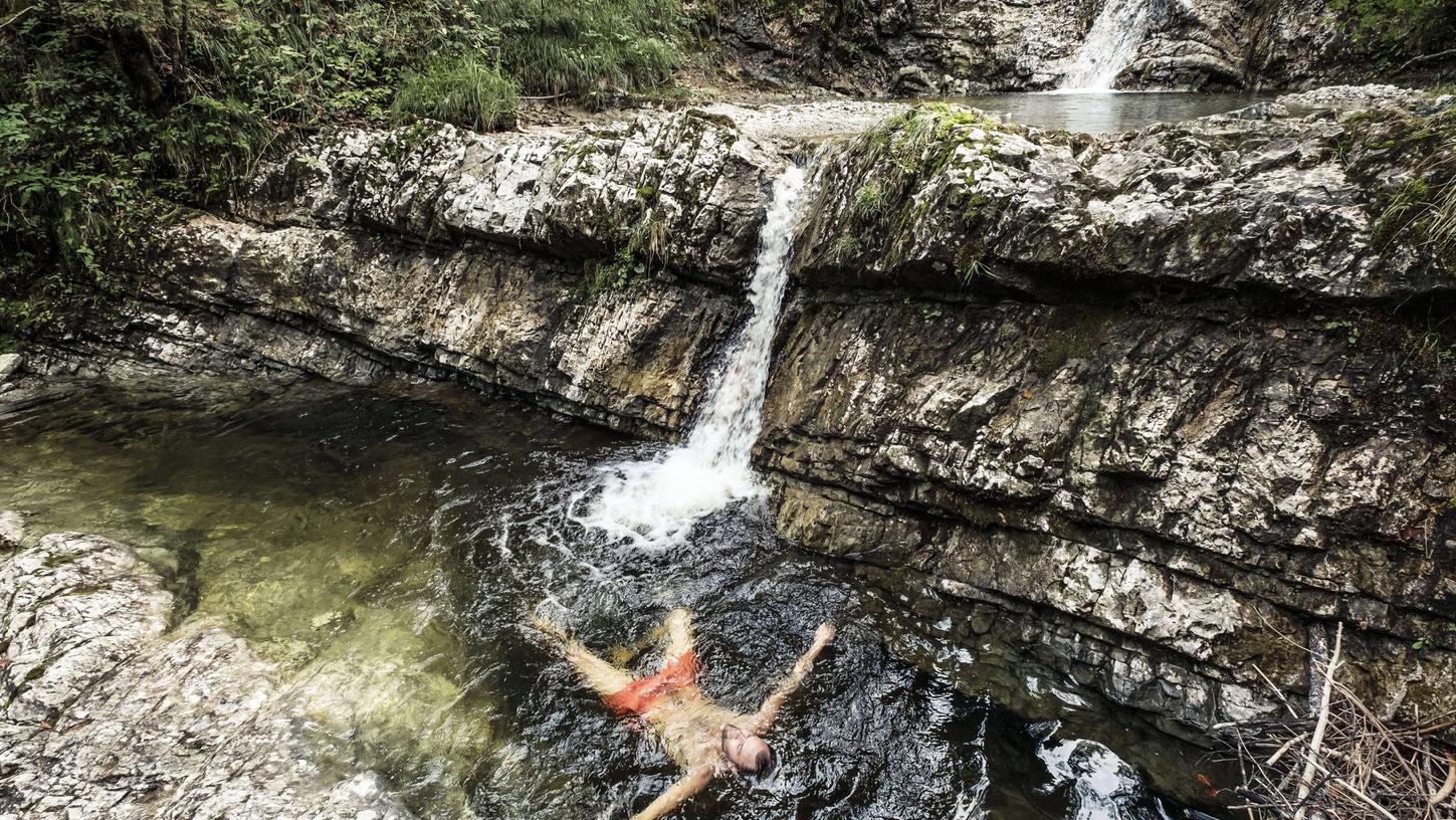 Kein tropischer Dschungel, sondern in Bayern: Fern allen Touristentrubels entspannt sich dieser Mann in einer Wasserkaskade im Wald nahe des Walchensees.