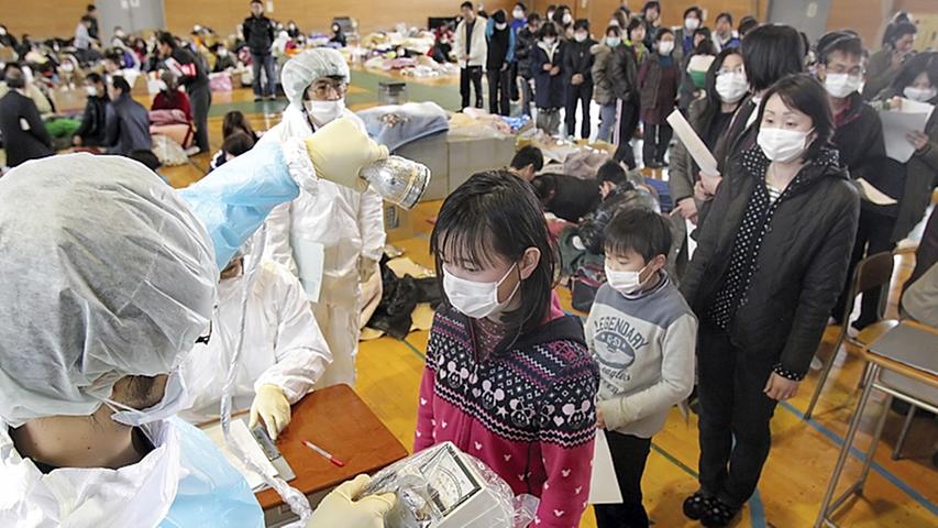 Die Angst geht um: Ärzte messen die mögliche Verstrahlung von Einwohnern der Stadt Fukushima, die in der Nähe des beschädigten Atomkraftwerks liegt.