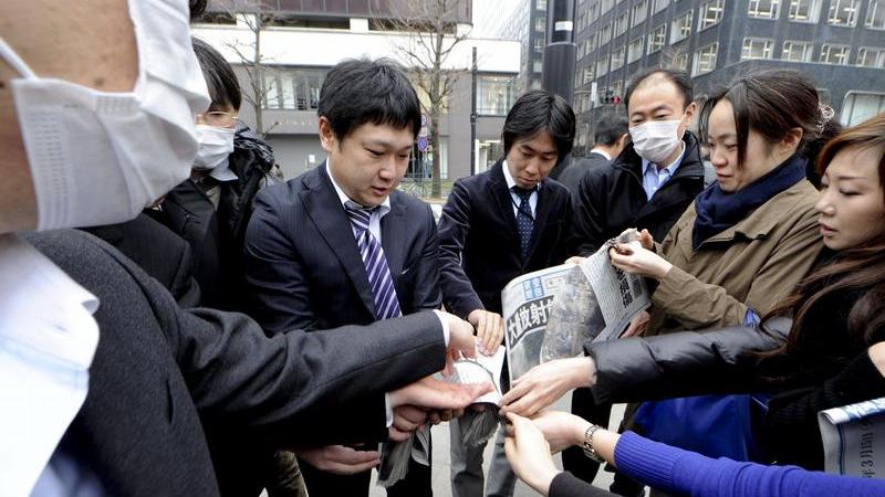 Ein Mann verteilt die Sonderausgabe einer Zeitung zum Reaktorunglück in Fukushima auf den Straßen von Tokio.