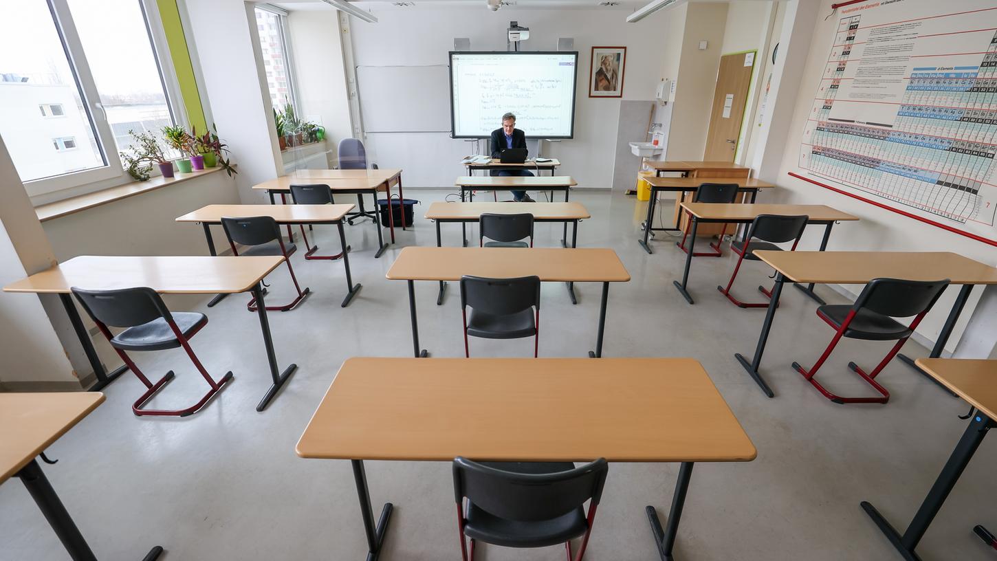 Ein Lehrer in Leipzig hält Digitalunterricht in einem leeren Klassenzimmer. 