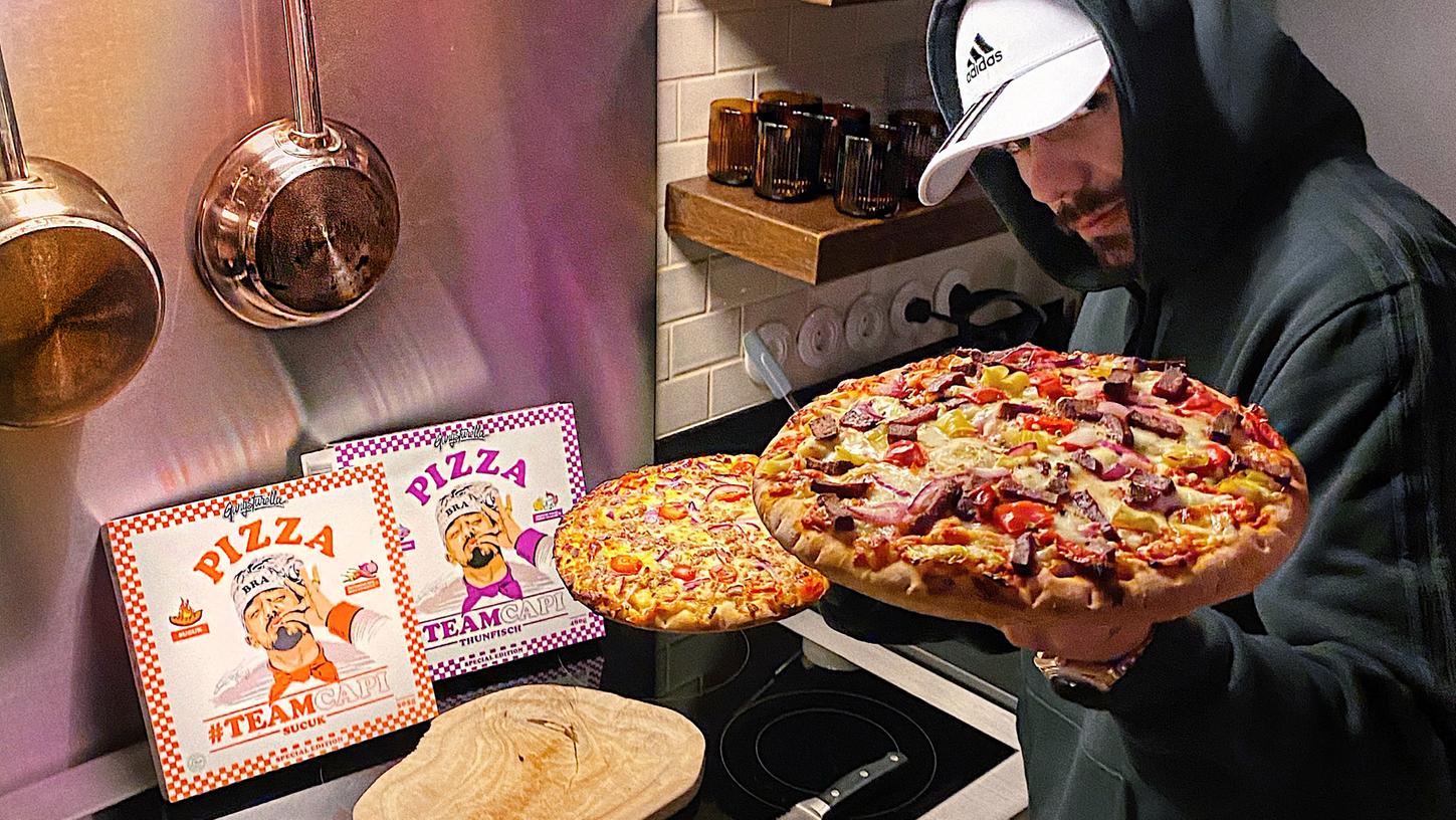 Capital Bra präsentiert seine neuen "Gangstarella"-Pizzen in gewohnter Gangster-Manier.
