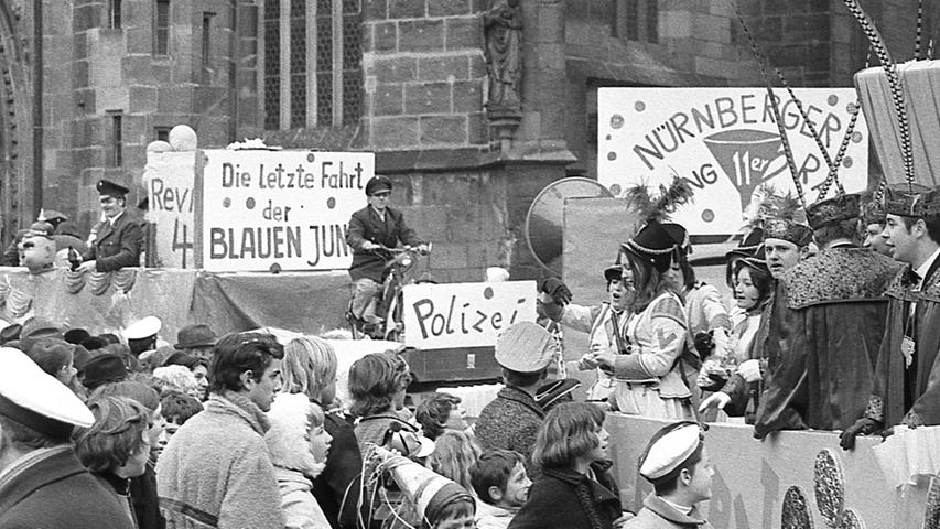 In den 1970er Jahren sorgte die Verstaatlichung der ursprünglich städtischen Polizei in Bayern für großen Zündstoff. Dies thematisiert der linke Wagen. Die Uniformen der städtischen Polizisten waren damals blau.