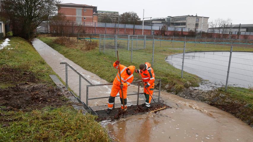Viel Wasser im Jägersburger Graben: Mitarbeiter der Stadt Forchheim versuchen, ein Wehr vor angeschwemmtem Material freizuhalten, um Überschwemmungen zu vermeiden. 