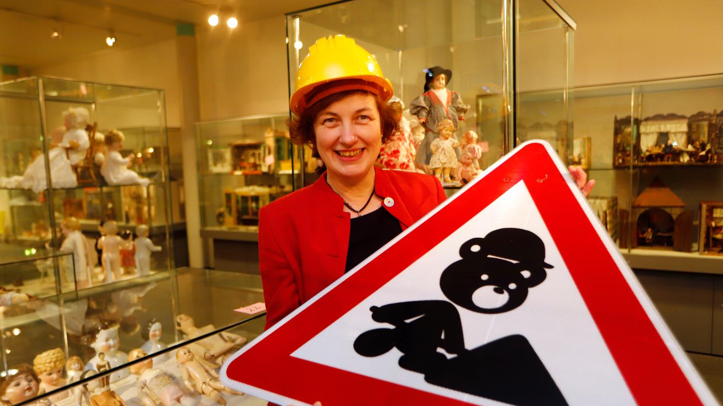 Karin Falkenberg, Direktorin des Spielzeugmuseums, hält ein Warnschild in Händen: Das Erdgeschoss des Hauses wird komplett neu gestaltet. Karin Falkenberg, Direktorin des Spielzeugmuseums, hält ein Warnschild in Händen: Das Erdgeschoss des Hauses wird komplett neu gestaltet.