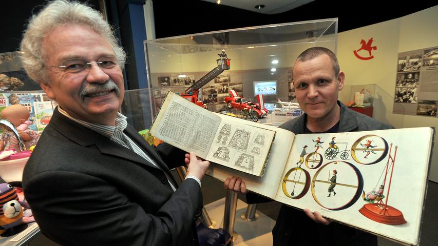 Der damalige Museumsdirektor Helmut Schwarz (links) hält den ältesten Spielzeugkatalog, den Bestelmeier-Katalog von 1823, in Händen. Ergänzend präsentiert Restaurator Urs Latus das Nürnberger Musterbuch für Blechspielwaren von circa 1850. Der damalige Museumsdirektor Helmut Schwarz (links) hält den ältesten Spielzeugkatalog, den Bestelmeier-Katalog von 1823, in Händen. Ergänzend präsentiert Restaurator Urs Latus das Nürnberger Musterbuch für Blechspielwaren von circa 1850.
