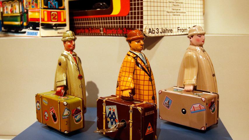 Reisende aus drei Blechspielzeugfirmen: Der Mann mit dem Koffer links stammt aus den 1950ern von der Zirndorfer Firma Fritz Voll. Die VEB Mechanische Spielwaren Brandenburg stellten zu DDR-Zeiten den mittleren Mann her. Und der rechte Kofferträger kam 2013 aus chinesischen Werkstätten. Reisende aus drei Blechspielzeugfirmen: Der Mann mit dem Koffer links stammt aus den 1950ern von der Zirndorfer Firma Fritz Voll. Die VEB Mechanische Spielwaren Brandenburg stellten zu DDR-Zeiten den mittleren Mann her. Und der rechte Kofferträger kam 2013 aus chinesischen Werkstätten.
